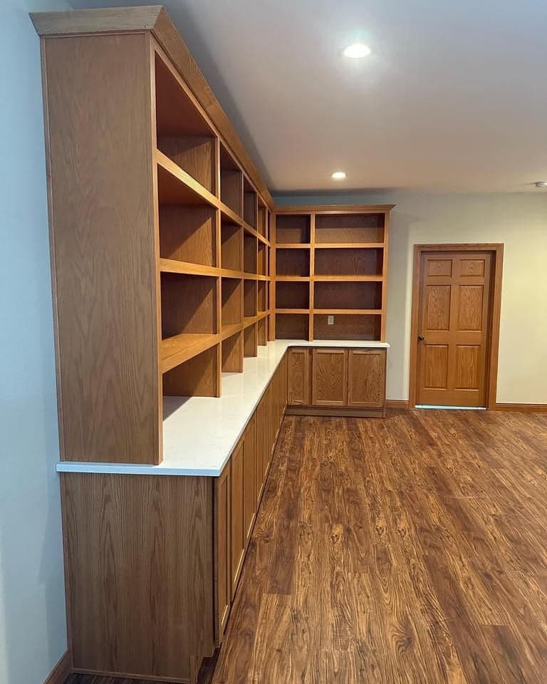 A custom oak built-in wall seen from the side, open shelving above a run of base cabinets.