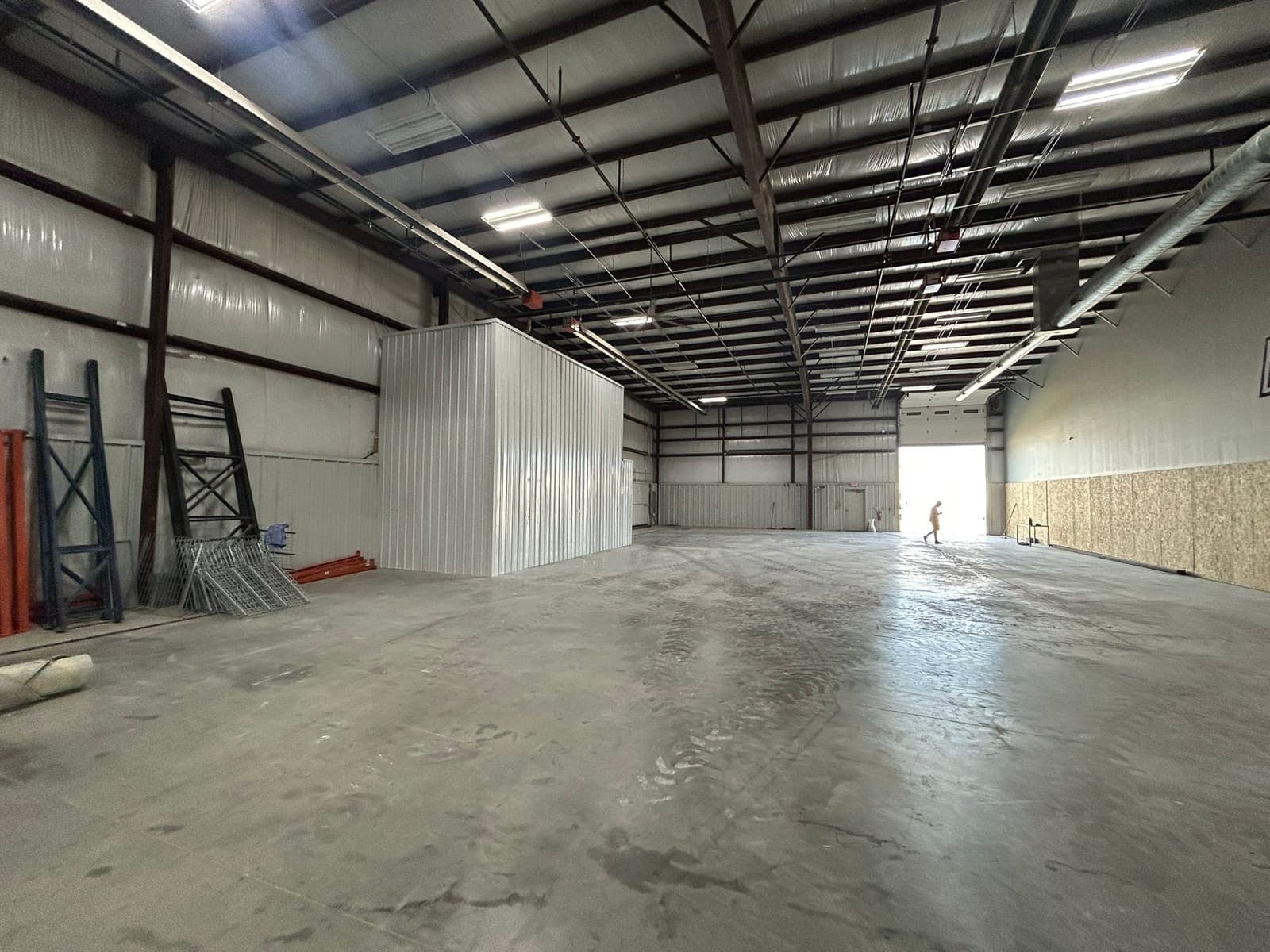 A new insulated partition built inside a steel-framed commercial unit, standing on a bare concrete floor.