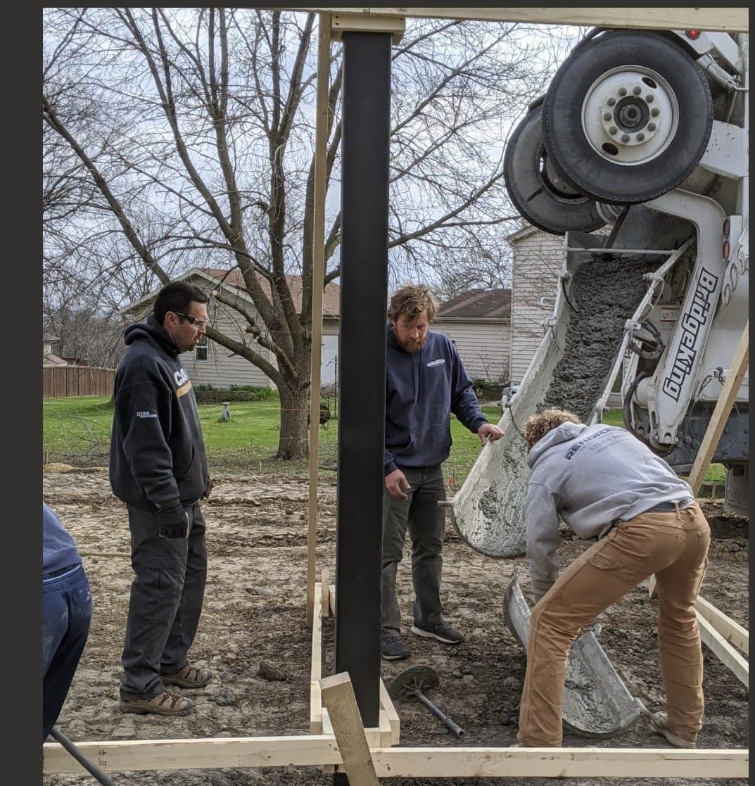 Concrete being placed from the truck into a formed footing
