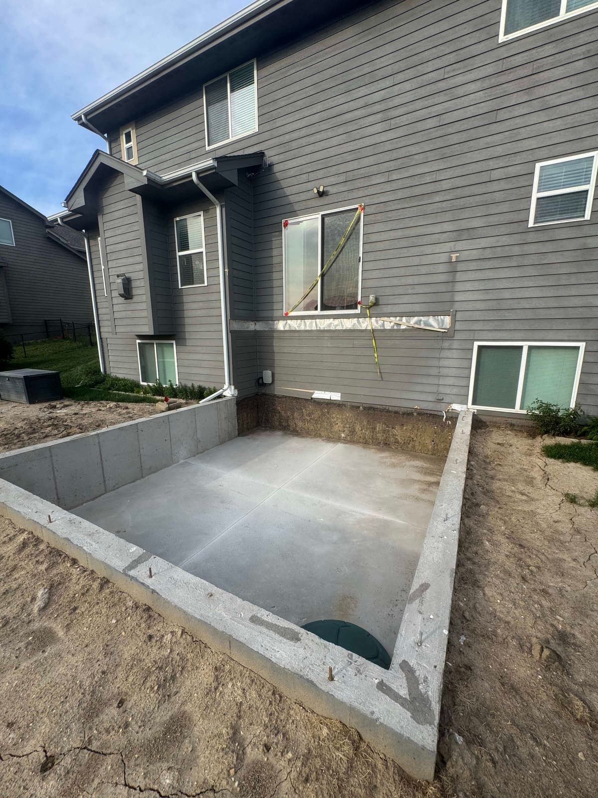 Freshly poured foundation walls and slab for a two-storey addition, ready for framing.