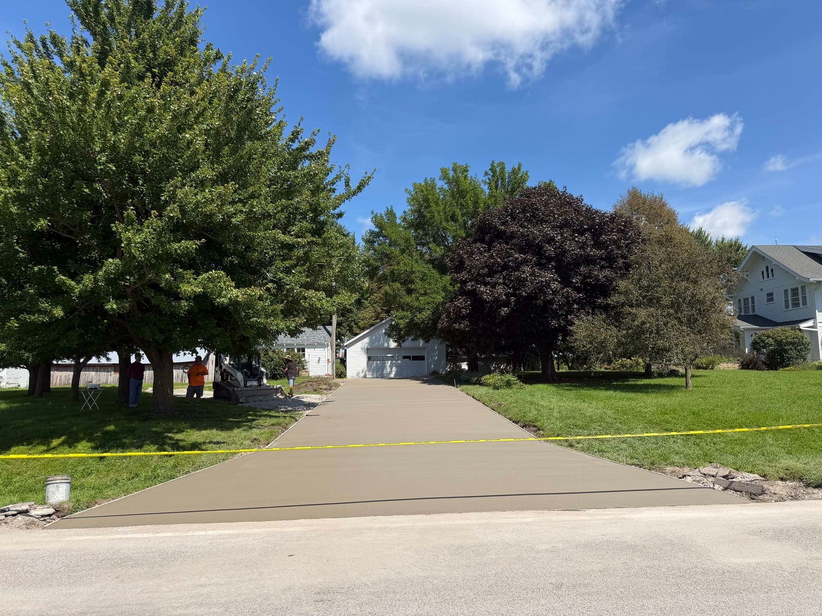 A driveway apron and walk just placed, still taped off from the street.