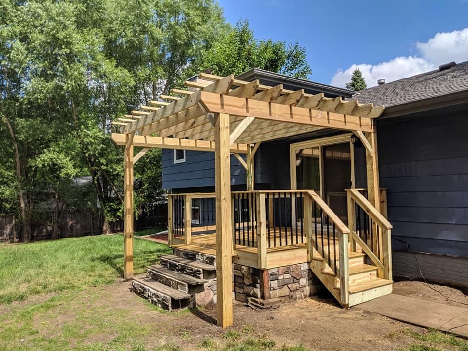 A cedar pergola over a deck, with stone steps