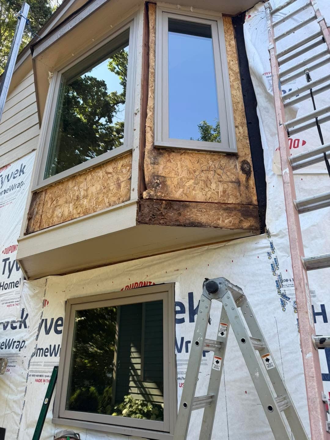 A bay window opened up, showing the rot in the framing behind it