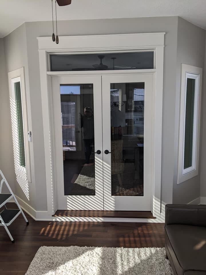 A pair of interior French doors with a glazed transom above and matching narrow lights either side.
