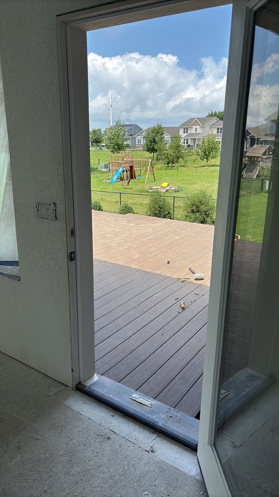 A new patio door standing open onto a composite deck.