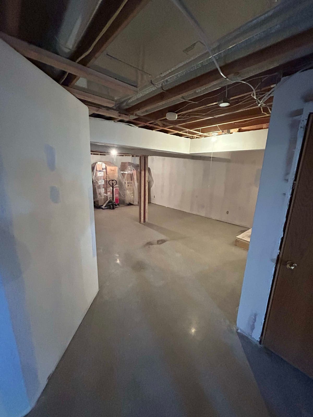 Basement walls freshly hung with drywall, seams still untaped.