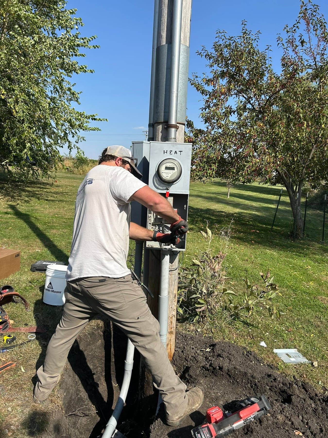 An electrician fitting a service meter to its post