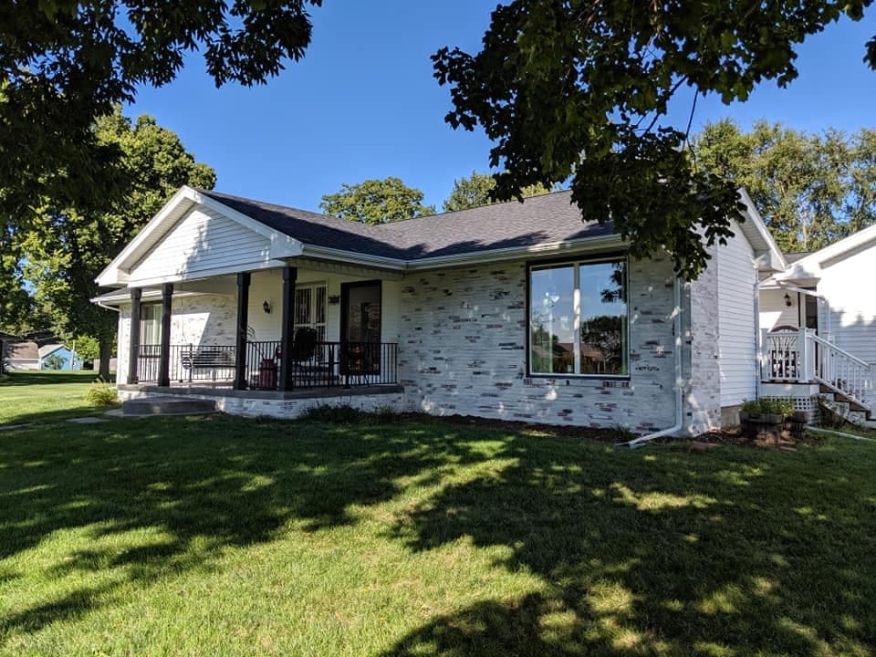 A brick ranch repainted white, with a covered front porch