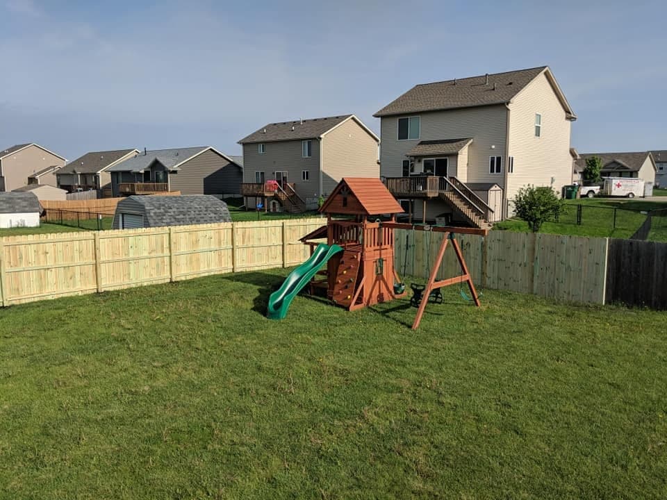 A wood privacy fence enclosing a back yard