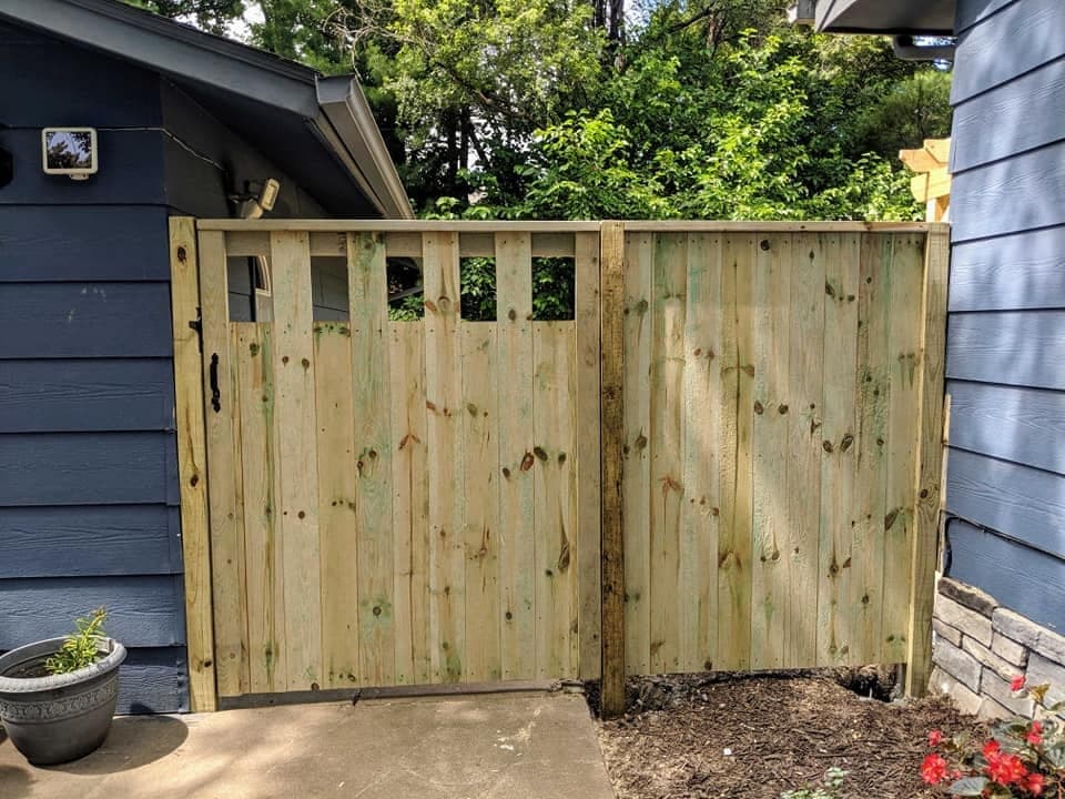 A wood gate built for the opening between a house and its garage